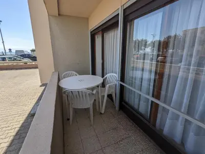 a balcony with a table and chairs and a window at T2 climatisé en front de mer avec parking - FR-1-797-13 in Port-la-Nouvelle