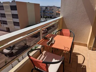 a living room with a couch and a wooden floor at Charmant T2 traversant, plage à 100m, balcon, bien équipé, idéal 4 personnes - FR-1-797-3 in Port-la-Nouvelle