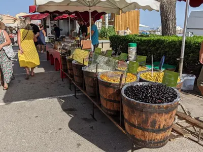 a market with a bunch of different types of food in barrels at Appartement T2 climatisé avec parking, près de la plage, 5 couchages - FR-1-797-12 in Port-la-Nouvelle