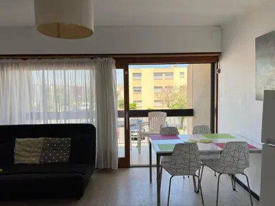 a living room with a couch and a table and chairs at Appartement T2 climatisé avec parking, près de la plage, 5 couchages - FR-1-797-12 in Port-la-Nouvelle