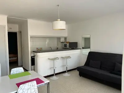 a living room with a couch and a kitchen at Appartement T2 climatisé avec parking, près de la plage, 5 couchages - FR-1-797-12 in Port-la-Nouvelle