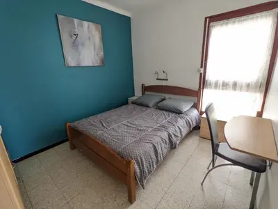 a bedroom with a bed and a blue wall at T2 face mer, climatisé, parking privé, 4 pers - FR-1-797-11 in Port-la-Nouvelle