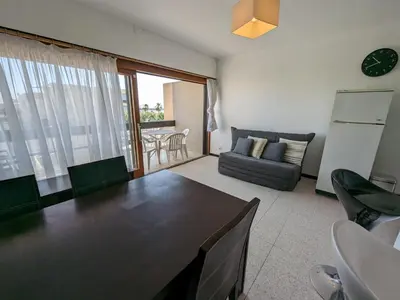 a living room with a table and a couch at T2 face mer, climatisé, parking privé, 4 pers - FR-1-797-11 in Port-la-Nouvelle