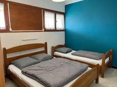 a room with two beds and a blue wall at Agréable T2 pour 5 pers, 1er étage, climatisé, parking sécurisé - FR-1-797-6 in Port-la-Nouvelle