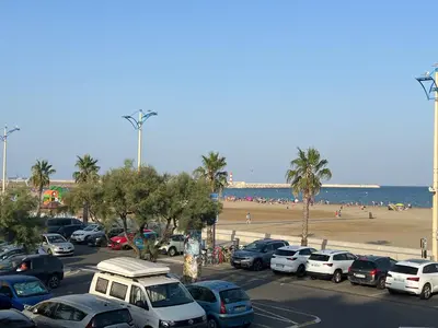 a parking lot with cars parked next to the beach at Agréable T2 pour 5 pers, 1er étage, climatisé, parking sécurisé - FR-1-797-6 in Port-la-Nouvelle