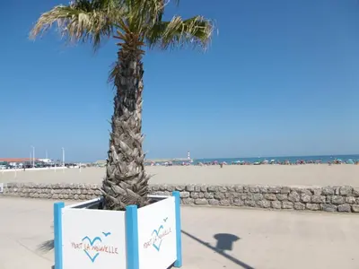 a group of people sitting under umbrellas on the beach at T3 duplex 50m², 2 chambres, proche plage, 6 pers - FR-1-797-1 in Port-la-Nouvelle