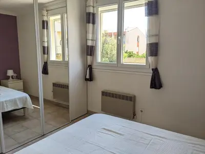 a bedroom with a bed and a large mirror at Appartement T2 lumineux 40m2, 4 personnes, 150m de la plage, bien équipé et proche loisirs - FR-1-797-18 in Port-la-Nouvelle