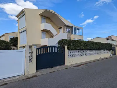 a house with a blue gate and a fence at Appartement T2 lumineux 40m2, 4 personnes, 150m de la plage, bien équipé et proche loisirs - FR-1-797-18 in Port-la-Nouvelle