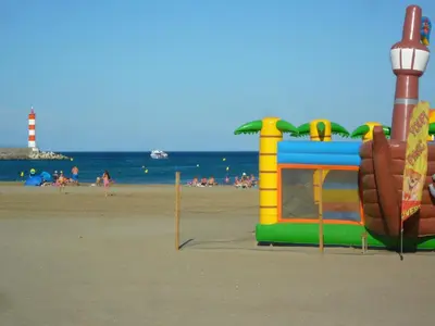 a playground on the beach with people in the water at Appartement T2 lumineux 40m2, 4 personnes, 150m de la plage, bien équipé et proche loisirs - FR-1-797-18 in Port-la-Nouvelle