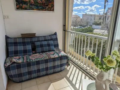 a balcony with a couch sitting on a balcony gmaxwell gmaxwell gmaxwell at Appartement T2 lumineux 40m2, 4 personnes, 150m de la plage, bien équipé et proche loisirs - FR-1-797-18 in Port-la-Nouvelle