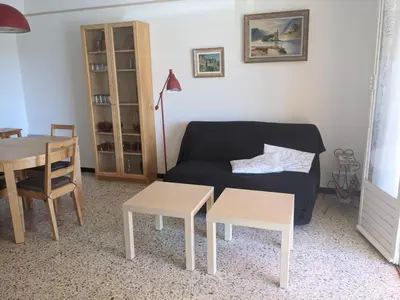 a living room with a couch and a table at Charmant T3 rénové à 60m de la plage avec terrasse, jardin et parking clos - FR-1-797-28 in Port-la-Nouvelle