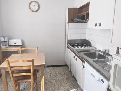 a small kitchen with a table and a sink at Charmant T3 rénové à 60m de la plage avec terrasse, jardin et parking clos - FR-1-797-28 in Port-la-Nouvelle