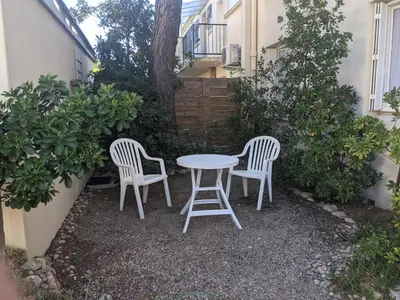 two chairs and a table in a yard with a table and chairs at Charmant T3 rénové à 60m de la plage avec terrasse, jardin et parking clos - FR-1-797-28 in Port-la-Nouvelle
