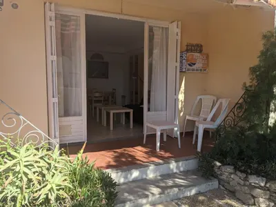 a porch with white chairs and a table at Charmant T3 rénové à 60m de la plage avec terrasse, jardin et parking clos - FR-1-797-28 in Port-la-Nouvelle