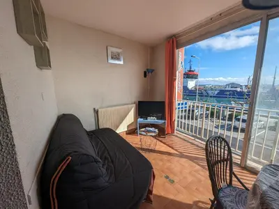 a living room with a couch and a balcony at Appartement T4 proche plage et commerces, 80m2, 6 pers, lave-linge, TV - FR-1-797-23 in Port-la-Nouvelle