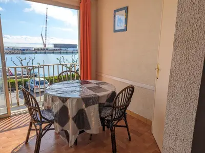 a dining room with a table and chairs and a balcony at Appartement T4 proche plage et commerces, 80m2, 6 pers, lave-linge, TV - FR-1-797-23 in Port-la-Nouvelle