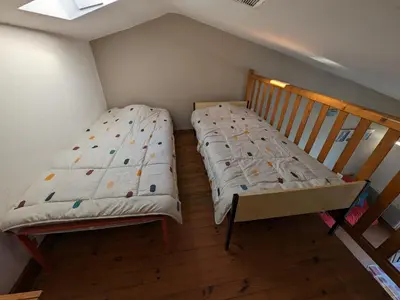 a small bedroom with a bed and a crib at Appartement T2 mezzanine 4/5 pers à 250m de la plage, balcon, vue panoramique - FR-1-797-26 in Port-la-Nouvelle