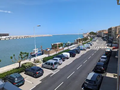 a line of cars parked on a street next to the ocean at Appartement T2 mezzanine 4/5 pers à 250m de la plage, balcon, vue panoramique - FR-1-797-26 in Port-la-Nouvelle