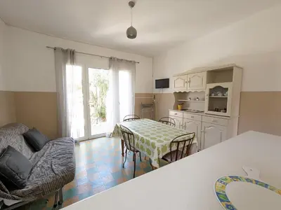 a kitchen and dining room with a table and chairs at Agréable T2, 4 pers, plain-pied ouvert sur terrasse, jardin clos, parking privé, proche plage et commerces - FR-1-797-24 in Port-la-Nouvelle
