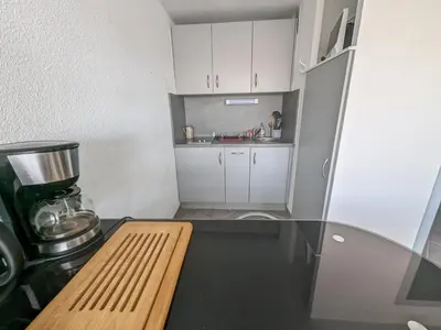 a small kitchen with a glass table and a counter top at Grand T2 Climatisé 36m² avec Parking à 450m de la Plage - 4 Pers - FR-1-797-34 in Port-la-Nouvelle