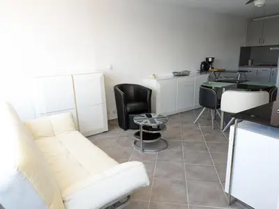 a living room with a couch and a table at Grand T2 Climatisé 36m² avec Parking à 450m de la Plage - 4 Pers - FR-1-797-34 in Port-la-Nouvelle