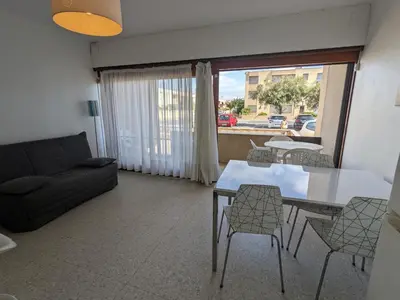 a living room with a couch and a table and chairs at T2 Climatisé, 5 pers, Parking Protégé, Front de mer - FR-1-797-38 in Port-la-Nouvelle