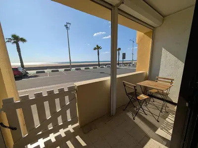 a balcony with a table and chairs and a view of the ocean at Appartement T2 Front de Mer avec Balcon et Parking – Confort et Activités à Proximité - FR-1-797-37 in Port-la-Nouvelle