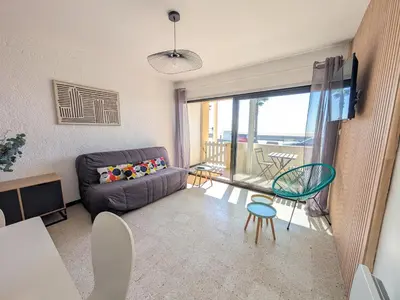 a living room with a couch and a table at Appartement T2 Front de Mer avec Balcon et Parking – Confort et Activités à Proximité - FR-1-797-37 in Port-la-Nouvelle
