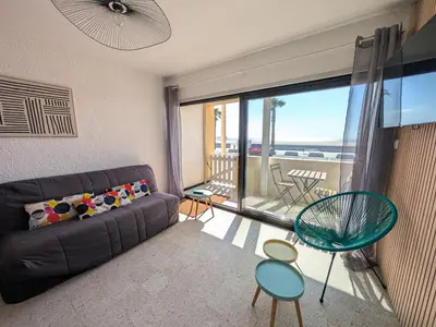 a living room with a couch and a balcony at Appartement T2 Front de Mer avec Balcon et Parking – Confort et Activités à Proximité - FR-1-797-37 in Port-la-Nouvelle