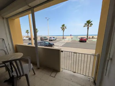 a balcony with a view of a parking lot and the beach at T2 en bord de mer pour 4 pers, RDC avec Parking - FR-1-797-39 in Port-la-Nouvelle