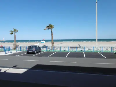 a car parked in a parking lot next to the beach at T2 en bord de mer pour 4 pers, RDC avec Parking - FR-1-797-39 in Port-la-Nouvelle