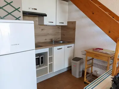 a small kitchen with white cabinets and a sink at T2 Mezzanine à 250m de la plage pour 4/5 pers avec Parking et TV - FR-1-797-31 in Port-la-Nouvelle