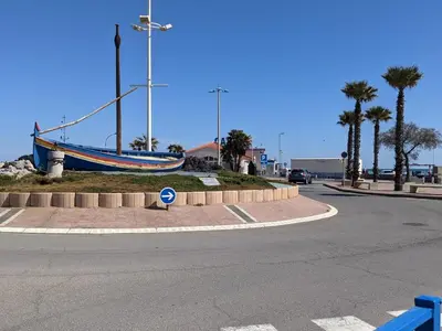 a boat sitting on the side of a road at T2 Mezzanine à 250m de la plage pour 4/5 pers avec Parking et TV - FR-1-797-31 in Port-la-Nouvelle