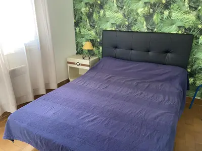 a bedroom with a bed with a purple bedspread at T2 Mezzanine à 250m de la plage pour 4/5 pers avec Parking et TV - FR-1-797-31 in Port-la-Nouvelle