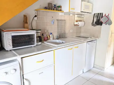 a small kitchen with a microwave and a sink at Belle Villa T3 Mezzanine, à 450m Plage, 5 Pers, Terrasse, Jardin, Garage & Parking - FR-1-797-33 in Port-la-Nouvelle