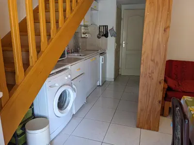 a kitchen with a washing machine and a staircase at Belle Villa T3 Mezzanine, à 450m Plage, 5 Pers, Terrasse, Jardin, Garage & Parking - FR-1-797-33 in Port-la-Nouvelle