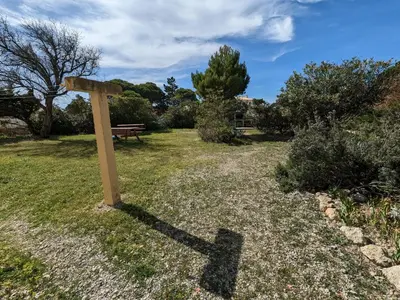 a wooden cross in the grass next to a bench at Charmant T2 proche plage à Port-la-Nouvelle, terrasse et parking inclus - FR-1-797-29 in Port-la-Nouvelle