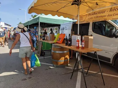 a woman walking past a food truck at a market at Charmant T2 proche plage à Port-la-Nouvelle, terrasse et parking inclus - FR-1-797-29 in Port-la-Nouvelle