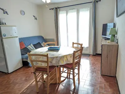 a kitchen with a table and chairs and a couch at Charmant T2 proche plage à Port-la-Nouvelle, terrasse et parking inclus - FR-1-797-29 in Port-la-Nouvelle