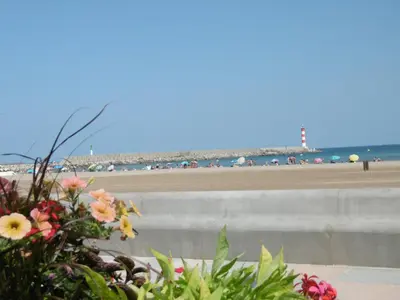 a stone pathway leading to the ocean with people walking on it at T3 Climatisé RDC avec Terrasse, Parking, Proche Activités - Port-la-Nouvelle - FR-1-797-30 in Port-la-Nouvelle