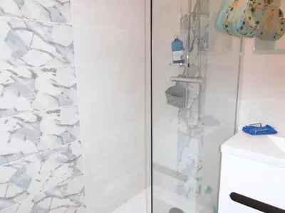 a shower with a glass door next to a sink at T3 Climatisé RDC avec Terrasse, Parking, Proche Activités - Port-la-Nouvelle - FR-1-797-30 in Port-la-Nouvelle
