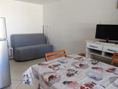 a living room with a table and a couch at Villa T2 Mezzanine Climatisée avec Cour - 6 Pers - Parking - Proche Plage - Meublé Tourisme 1* - FR-1-797-44 in Port-la-Nouvelle