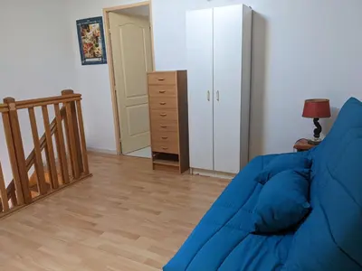 a living room with a blue couch and a closet at Villa T2 Mezzanine Climatisée avec Cour - 6 Pers - Parking - Proche Plage - Meublé Tourisme 1* - FR-1-797-44 in Port-la-Nouvelle