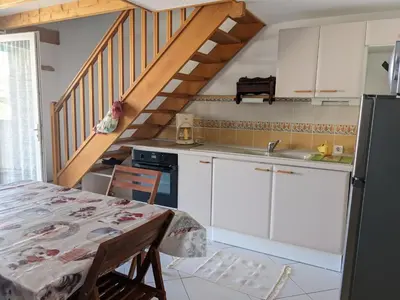 a kitchen with white cabinets and a staircase at Villa T2 Mezzanine Climatisée avec Cour - 6 Pers - Parking - Proche Plage - Meublé Tourisme 1* - FR-1-797-44 in Port-la-Nouvelle