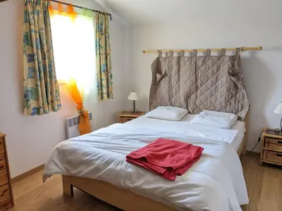 a bedroom with a bed with a red towel on it at Belle villa climatisée T3 avec mezzanine, jardin arboré, garage et à 900m de la plage, 6/7 personnes - FR-1-797-36 in Port-la-Nouvelle