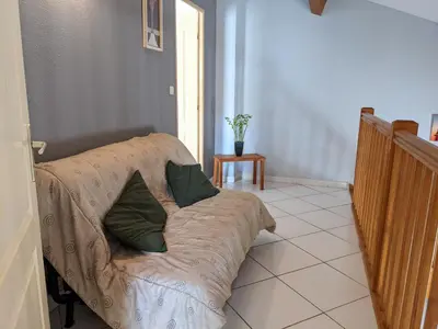 a couch with two pillows on it in a room at Belle villa climatisée T3 avec mezzanine, jardin arboré, garage et à 900m de la plage, 6/7 personnes - FR-1-797-36 in Port-la-Nouvelle