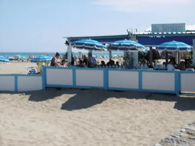 a group of people sitting under umbrellas on the beach at Belle villa climatisée T3 avec mezzanine, jardin arboré, garage et à 900m de la plage, 6/7 personnes - FR-1-797-36 in Port-la-Nouvelle