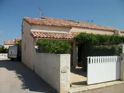 a house with a white fence and a white gate at Belle villa climatisée T3 avec mezzanine, jardin arboré, garage et à 900m de la plage, 6/7 personnes - FR-1-797-36 in Port-la-Nouvelle