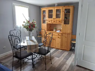 a dining room with a table and chairs and a wooden cabinet at Belle villa climatisée T3 avec mezzanine, jardin arboré, garage et à 900m de la plage, 6/7 personnes - FR-1-797-36 in Port-la-Nouvelle