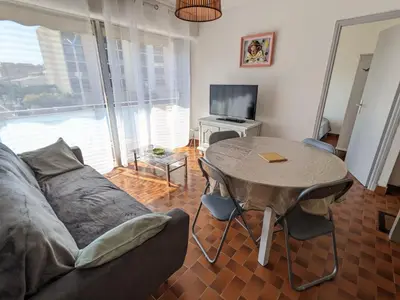 a living room with a couch and a table at T3 spacieux climatisé - 5 pers - près plage, centre & animations - Parking privé - FR-1-797-22 in Port-la-Nouvelle